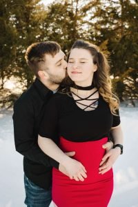 Maternity couple with guy kissing girl