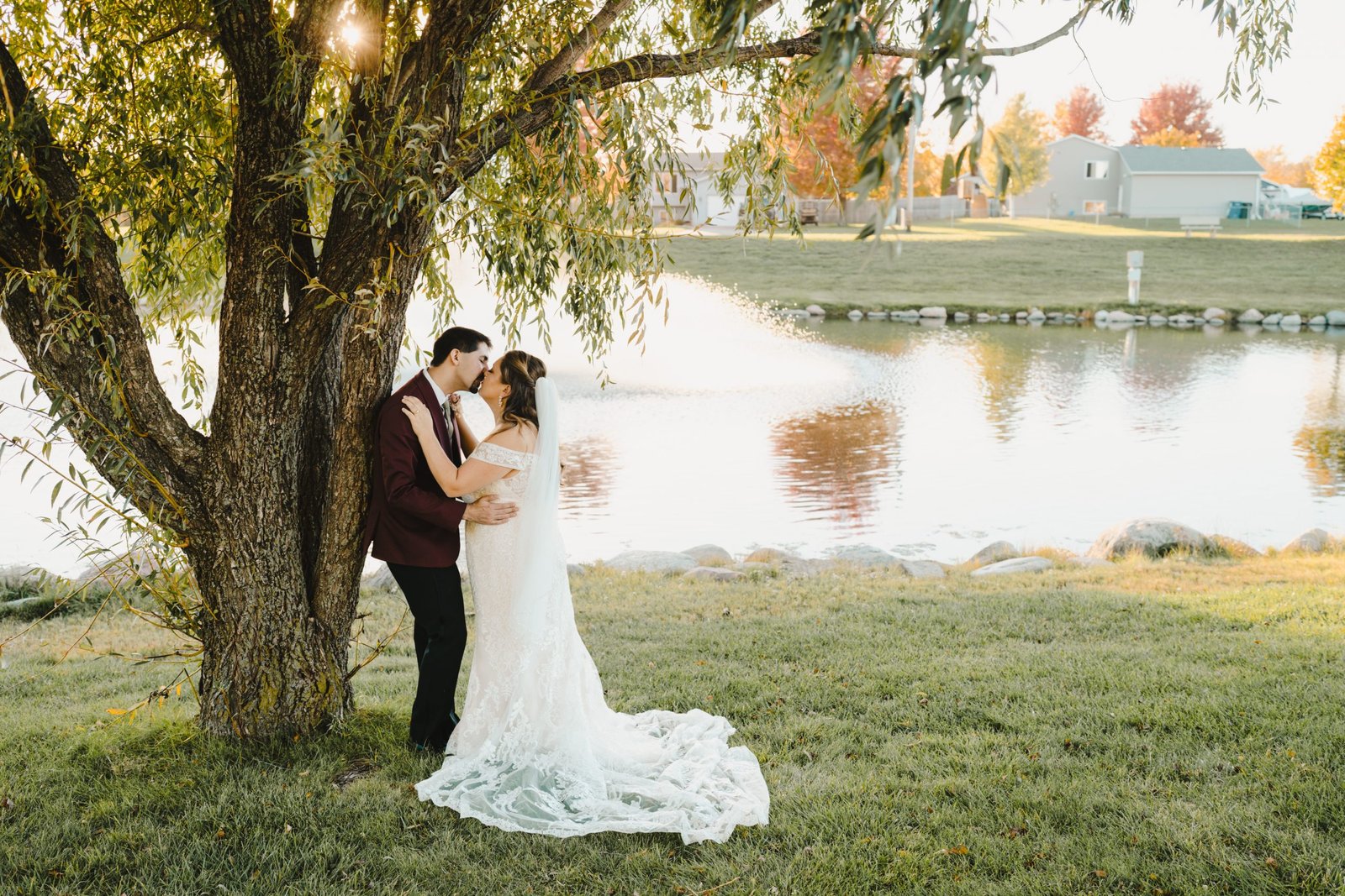 Wedding couple kissing next to a tree
