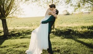 Bride getting picked up by groom about to kiss
