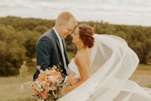 Wedding couple looking at each other with veil in the wind