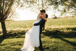 Bride getting picked up by groom about to kiss