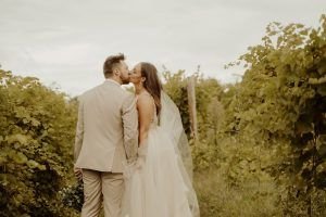 Wedding couple kissing in vineyard