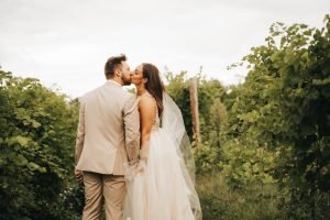 Wedding couple kissing in vineyard