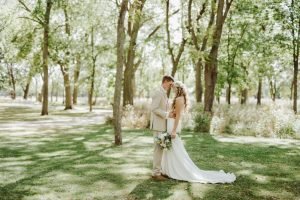 Wedding couple in a field with trees