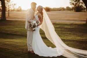 Wedding couple about to kiss on a golf course
