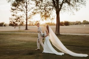 Bride and groom walking on a golf course