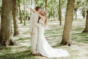 Wedding couple in a field with trees