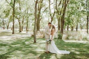 Wedding couple in a field with trees