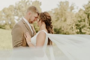 Wedding couple looking at each other with veil in the wind