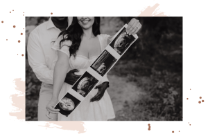 Maternity couple holding ultrasound pictures