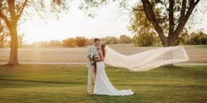 Wedding couple kissing with veil in the air
