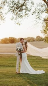 Wedding couple kissing with veil in the air