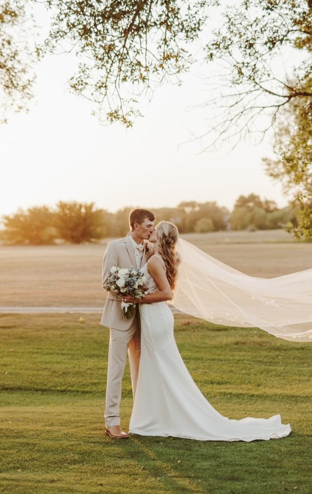 Wedding couple kissing with veil in the air Wedding couple kissing with veil in the air