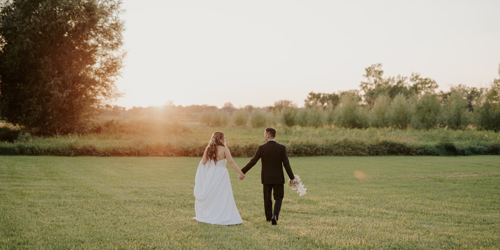 Wedding couple walking towards the sunset together