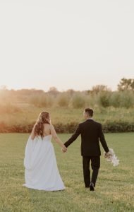 Wedding couple walking towards the sunset together