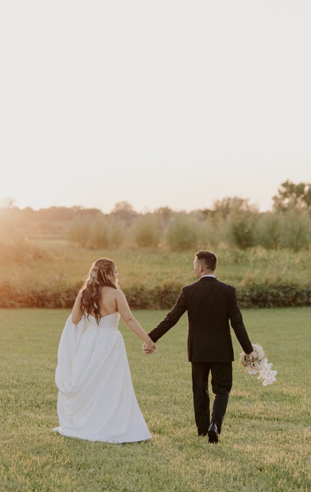 Wedding couple walking towards the sunset together