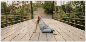 Senior session girl sitting on a bridge