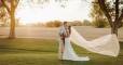Wedding couple looking at each other with veil in wind