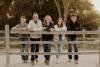 Family leaning on a fence